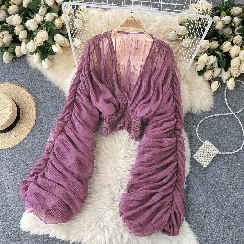 Blusa feminina de manga bufante longa e com dobras.