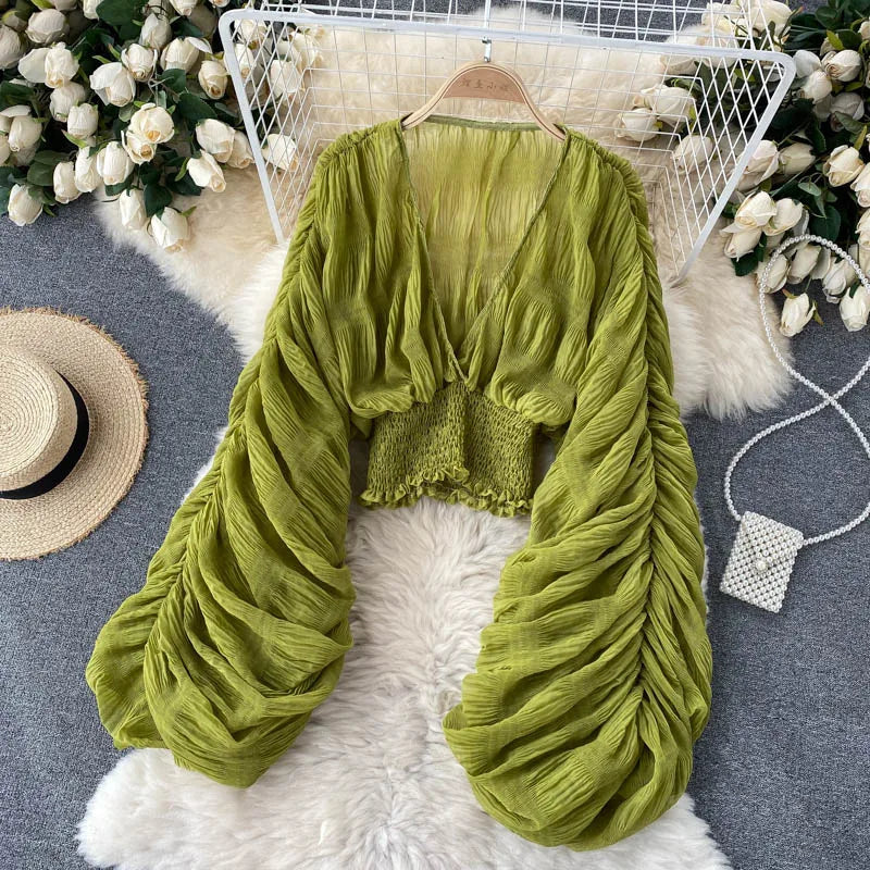 Blusa feminina de manga bufante longa e com dobras.