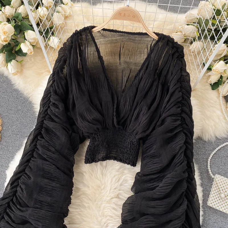 Blusa feminina de manga bufante longa e com dobras.